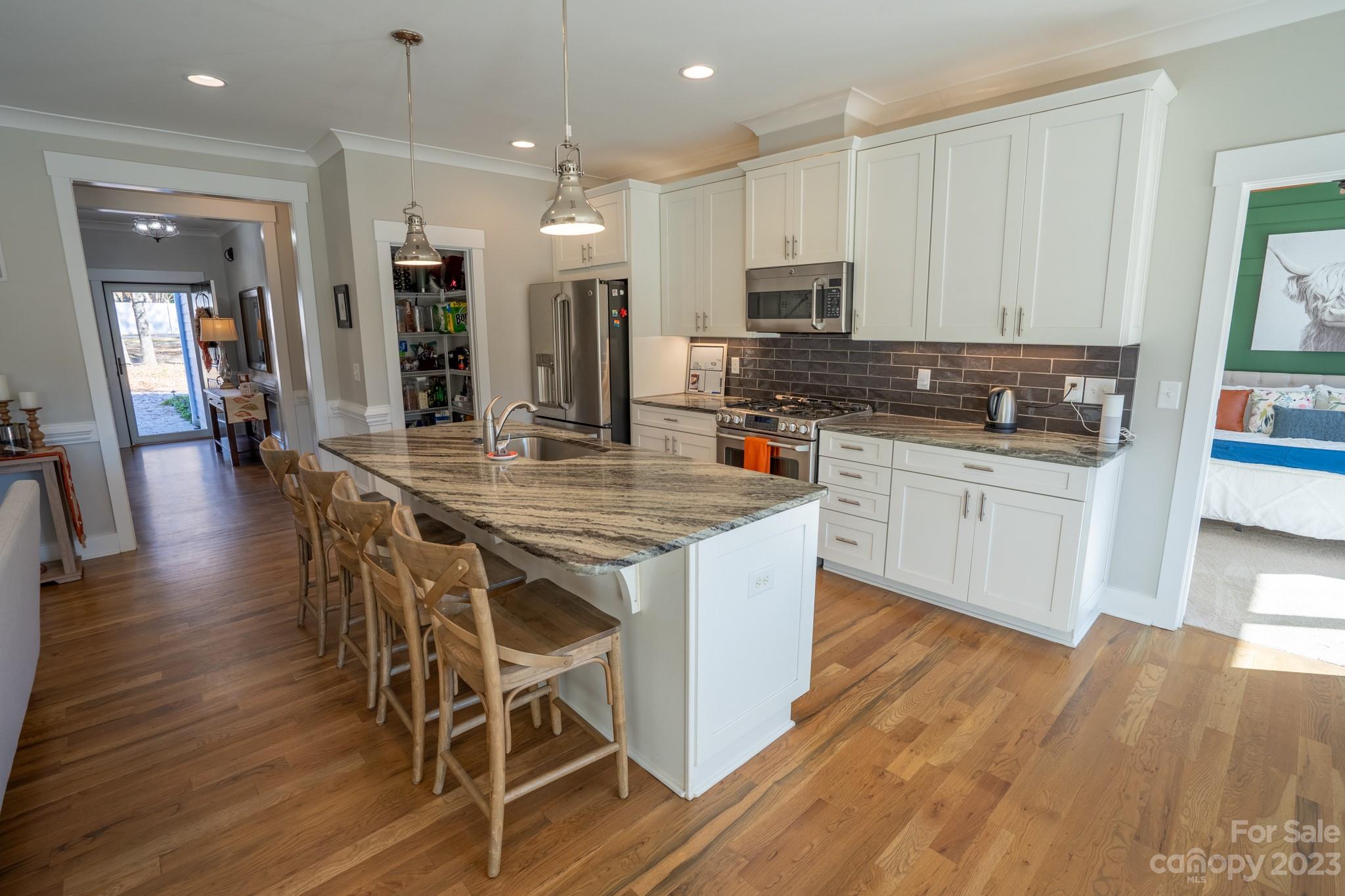 1411 Mary Ellen Drive Fort Mill, SC 29708 - Photo 17 of 37 a kitchen with stainless steel appliances a dining table chairs stove refrigerator and cabinets