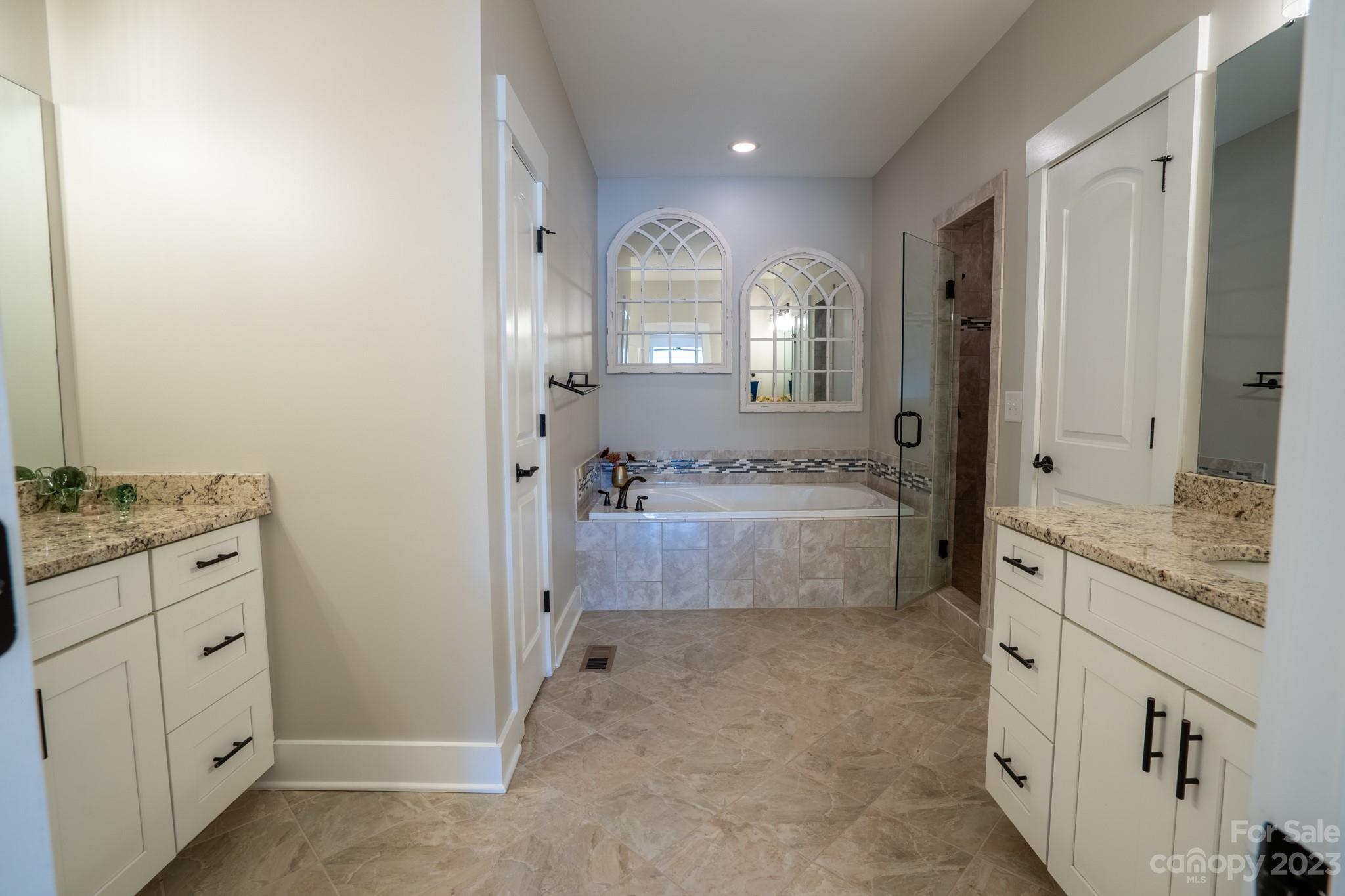1411 Mary Ellen Drive Fort Mill, SC 29708 - Photo 26 of 37 a spacious bathroom with a granite countertop sink a mirror and a bathtub