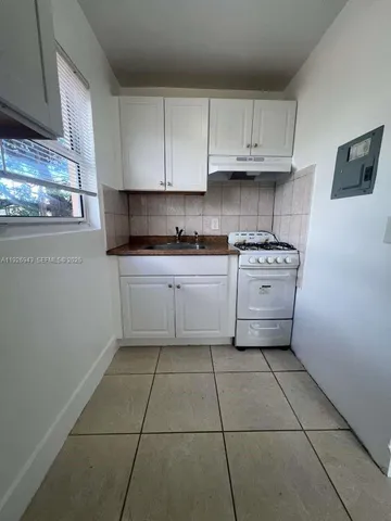 a kitchen with stainless steel appliances granite countertop a stove a sink and a white cabinets