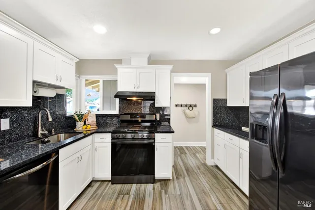 a kitchen with stainless steel appliances a refrigerator sink and white cabinets