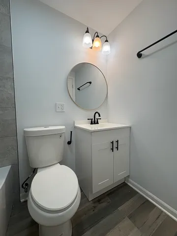 a bathroom with a toilet a sink and mirror
