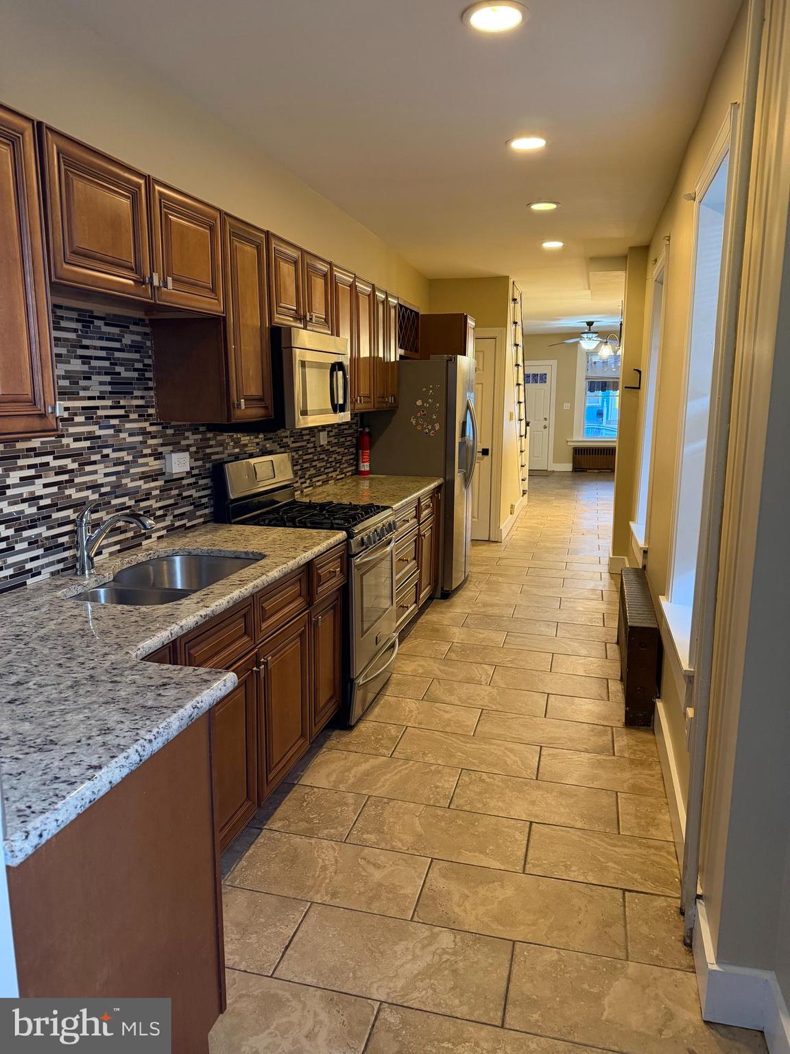 1255 Buttonwood Street Reading, PA 19604 - Photo 6 of 14 a kitchen with stainless steel appliances granite countertop a sink stove and cabinets