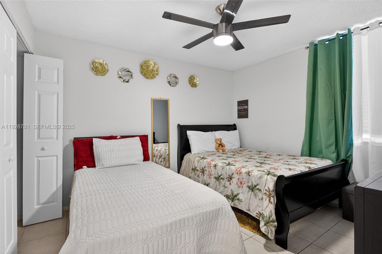 6195 Rock Island Road, Unit 103 Tamarac, FL 33319 - Photo 12 of 27 a bedroom with two beds and a chandelier