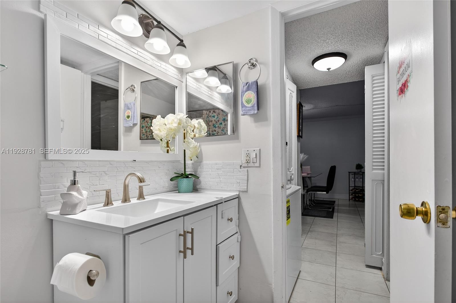 6195 Rock Island Road, Unit 103 Tamarac, FL 33319 - Photo 16 of 27 a bathroom with a sink and a mirror