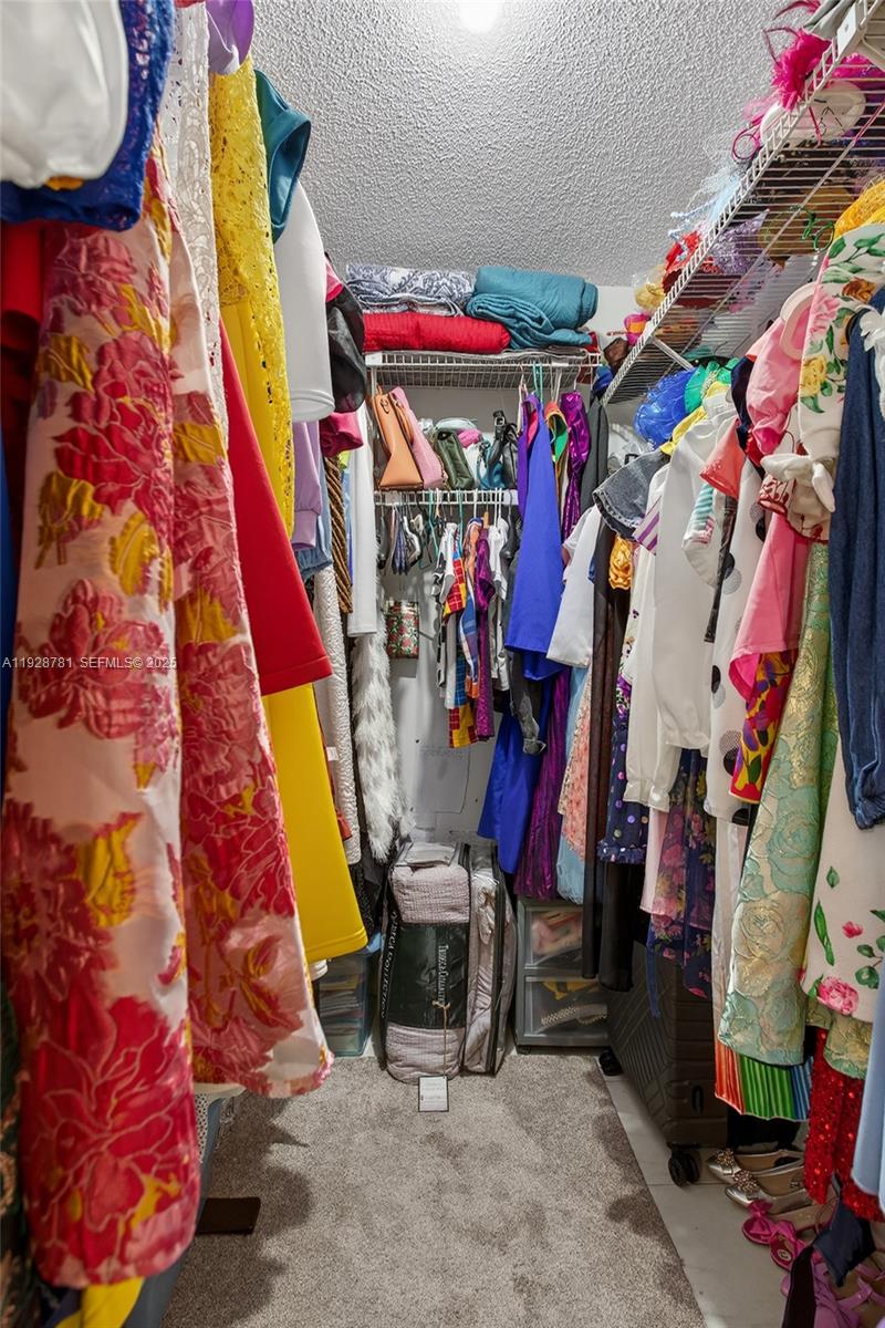6195 Rock Island Road, Unit 103 Tamarac, FL 33319 - Photo 17 of 27 a view of walk in closet with clothes