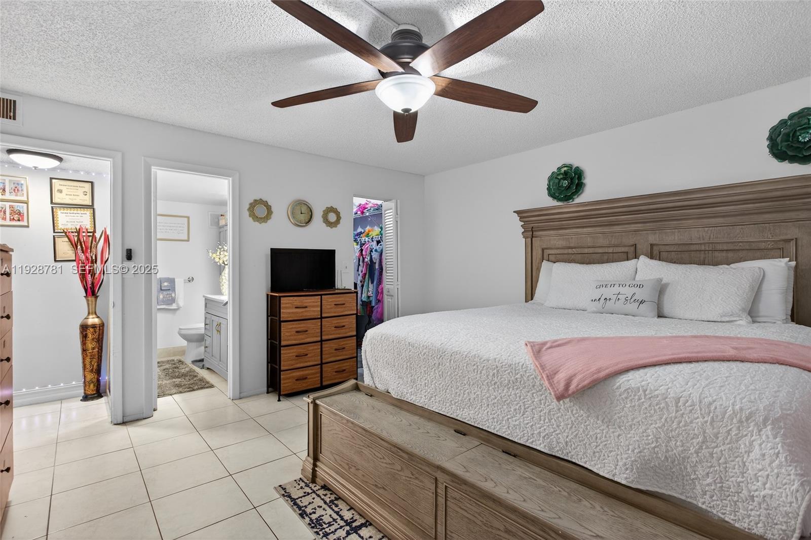 6195 Rock Island Road, Unit 103 Tamarac, FL 33319 - Photo 18 of 27 a bedroom with a bed and a ceiling fan