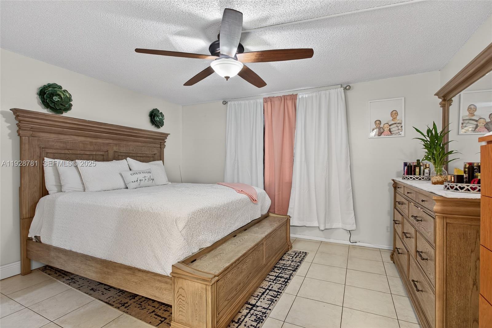 6195 Rock Island Road, Unit 103 Tamarac, FL 33319 - Photo 19 of 27 a bed room with a bed and a chandelier