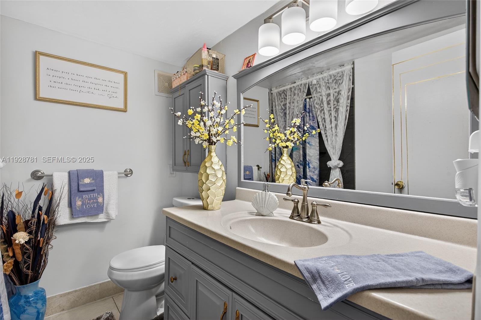 6195 Rock Island Road, Unit 103 Tamarac, FL 33319 - Photo 22 of 27 a bathroom with a granite countertop toilet sink and mirror