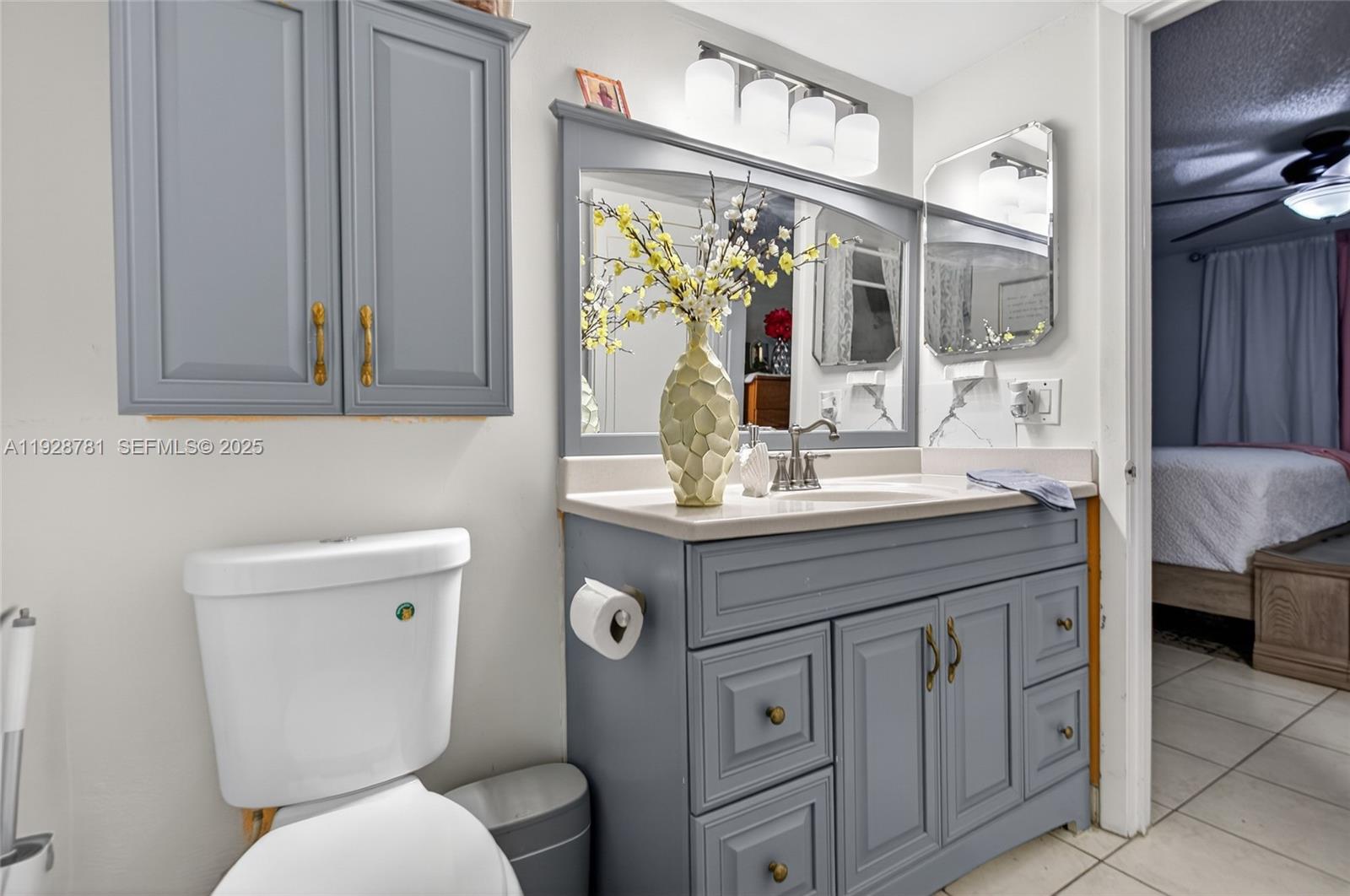 6195 Rock Island Road, Unit 103 Tamarac, FL 33319 - Photo 24 of 27 a bathroom with a granite countertop toilet sink and mirror