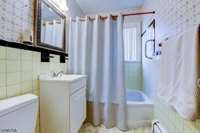 a bathroom with a sink a toilet and shower curtain