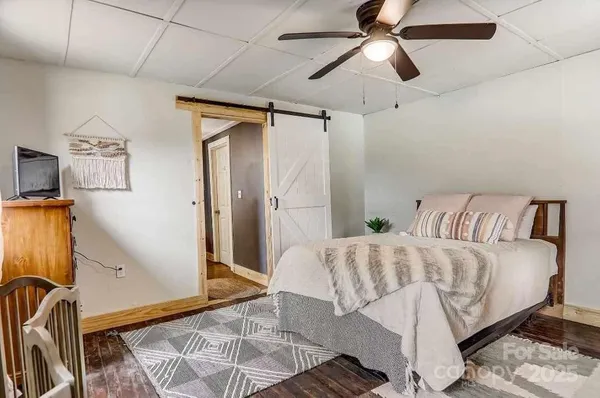a living room with a bed furniture and a flat screen tv