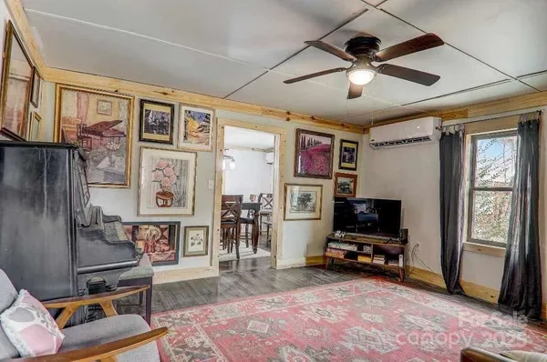 a living room with furniture a flat screen tv and a rug
