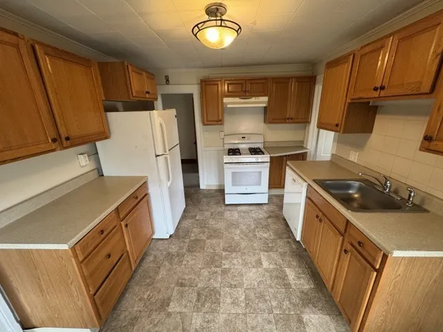 a kitchen with a refrigerator stove top oven sink and cabinets