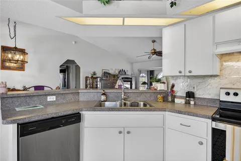 a kitchen with stainless steel appliances granite countertop a sink a stove and cabinets