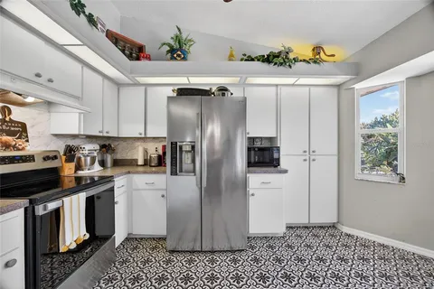 a kitchen with stainless steel appliances granite countertop a refrigerator a stove a microwave and cabinets