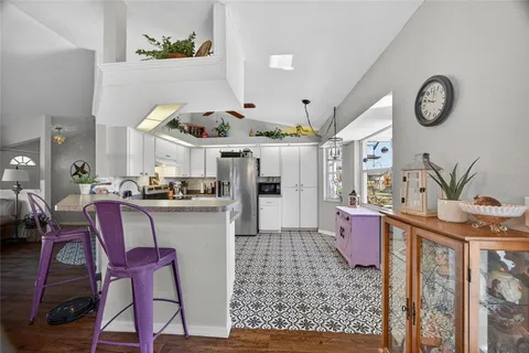 a kitchen with stainless steel appliances kitchen island granite countertop a table and chairs in it