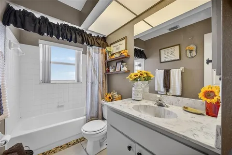 a bathroom with a granite countertop sink mirror vanity bathtub and a toilet