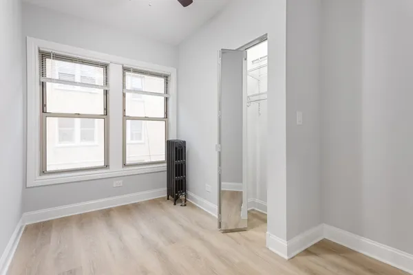 an empty room with windows and closet