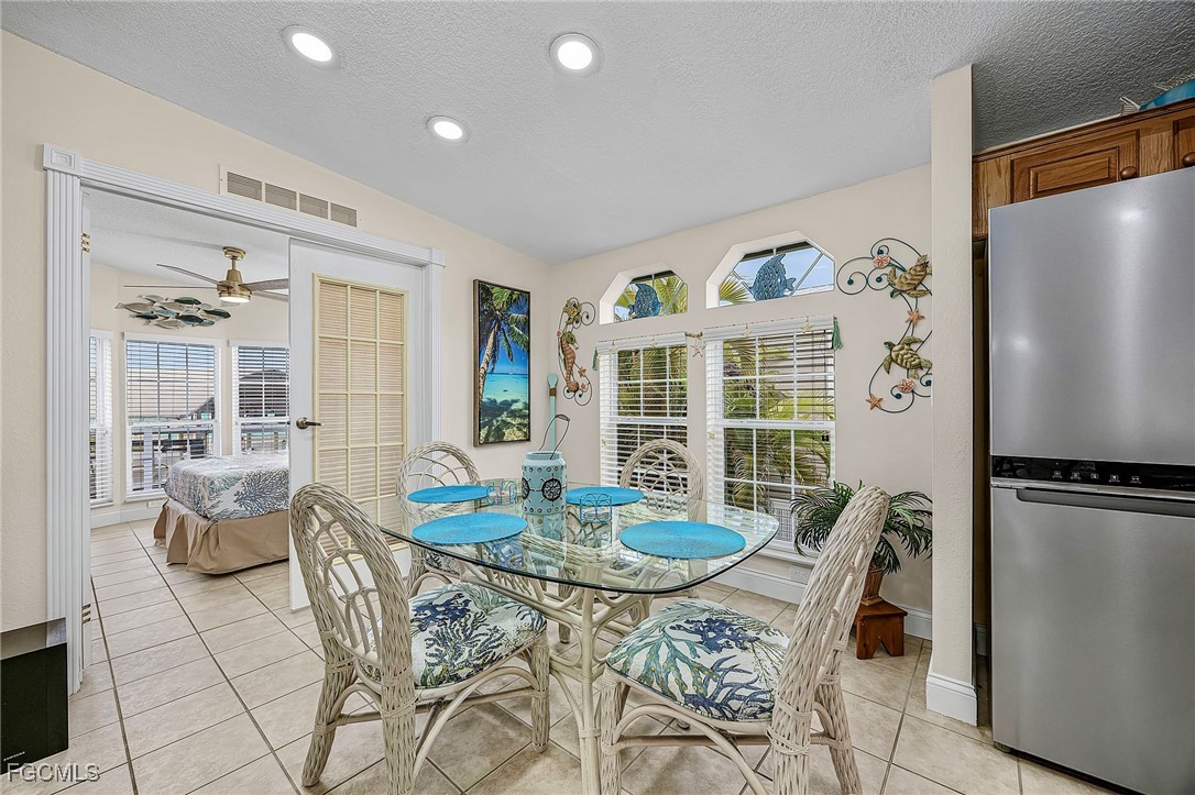 2991 Sloop Lane St. James City, FL 33956 - Photo 12 of 43 a dining room with furniture a kitchen view and a refrigerator