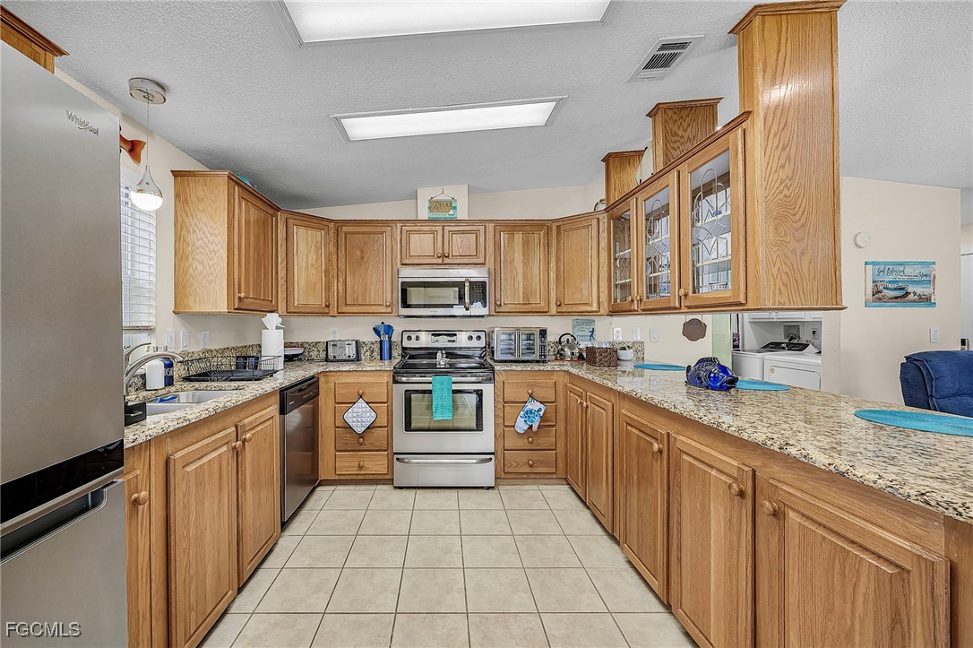 2991 Sloop Lane St. James City, FL 33956 - Photo 13 of 43 a kitchen with stainless steel appliances granite countertop a stove sink and cabinets