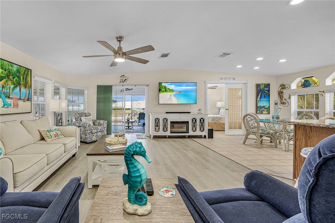 2991 Sloop Lane St. James City, FL 33956 - Photo 24 of 43 a living room with furniture kitchen view and a wooden floor