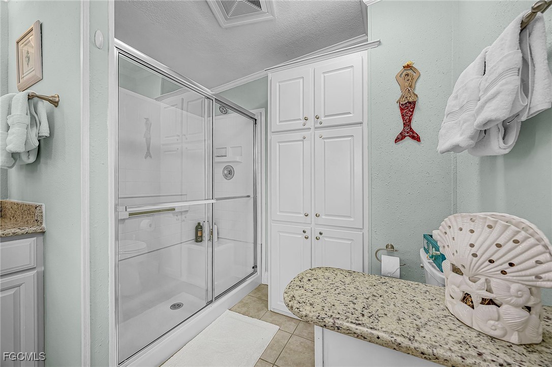 2991 Sloop Lane St. James City, FL 33956 - Photo 41 of 43 a bathroom with a granite countertop sink a toilet and shower