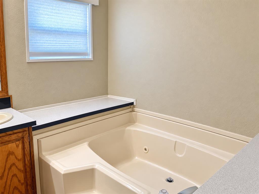 301 South Coppell Road, Unit 51 Coppell, TX 75019 - Photo 12 of 20 Built-in corner bathtub with integrated jets and surrounding countertop