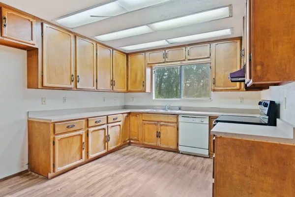 a kitchen with stainless steel appliances granite countertop wooden cabinets a sink and a stove