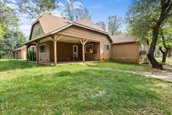 a view of a house with backyard and a tree