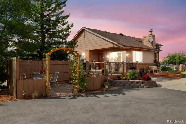 a view of a chair and tables in the back yard of the house