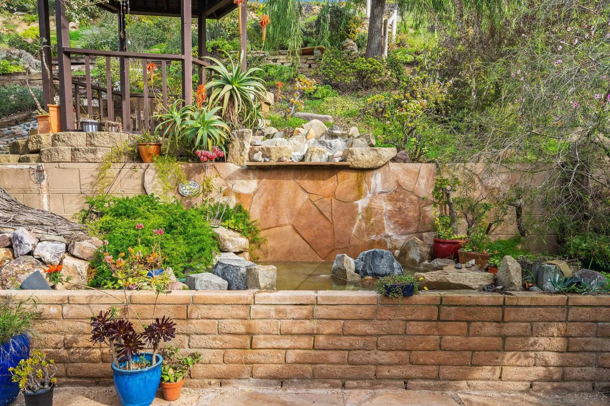 1849 Playa Riviera Drive Cardiff, CA 92007 - Photo 14 of 43 Garden with Waterfall Fountain feature behind patio in backyard.