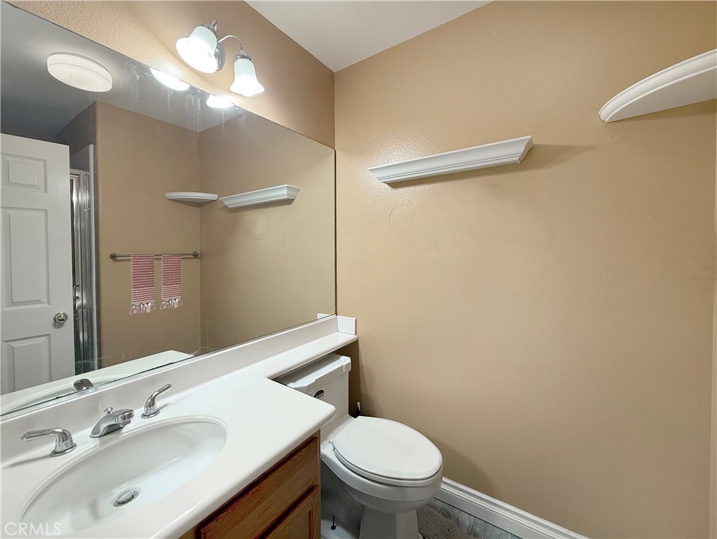 23964 Old Pomegranate Road Yorba Linda, CA 92887 - Photo 26 of 30 a bathroom with a sink vanity mirror and toilet