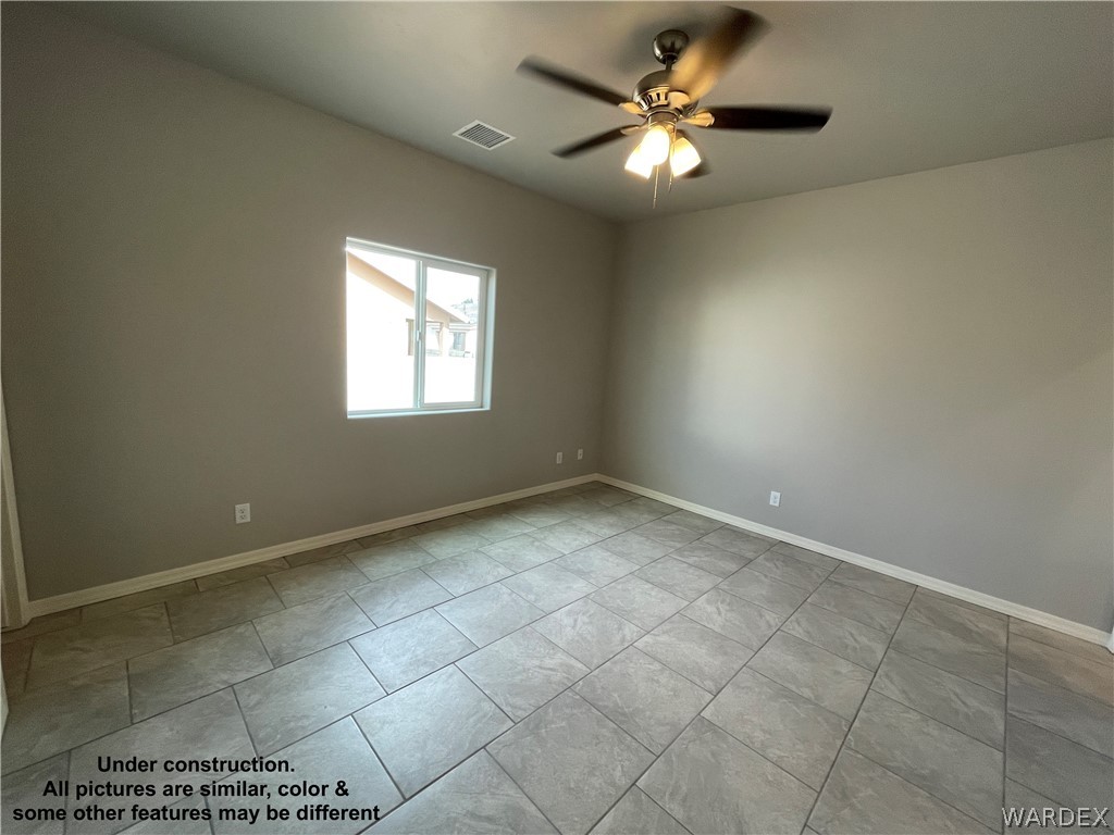 3555 North Kenneth Road Kingman, AZ 86409 - Photo 12 of 19 a view of an empty room with a ceiling fan and window