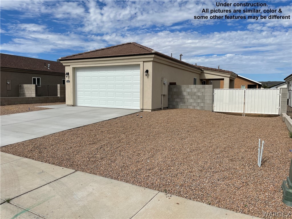 3555 North Kenneth Road Kingman, AZ 86409 - Photo 4 of 19 a front view of a house with a yard and garage