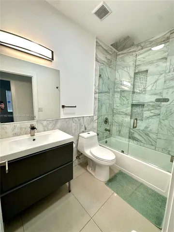 a bathroom with a double vanity sink toilet and shower