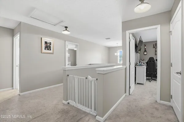 a view of a hallway with a livingroom and a bathroom