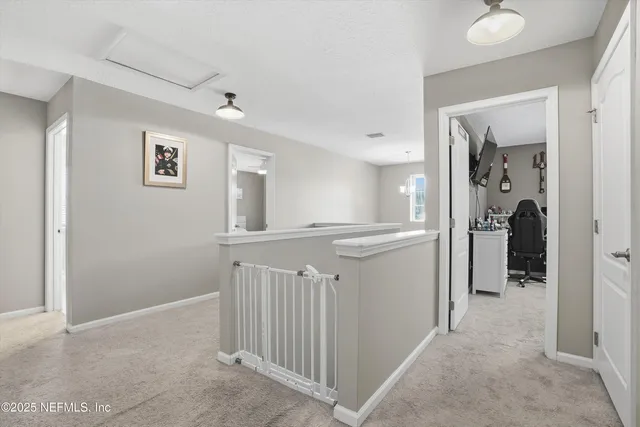 a view of a hallway with a livingroom and a bathroom