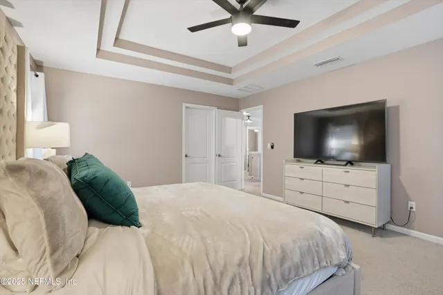 a bedroom with a bed tv and flat screen tv