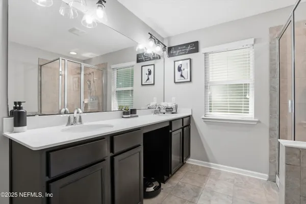 a bathroom with a sink double vanity granite tub and a mirror