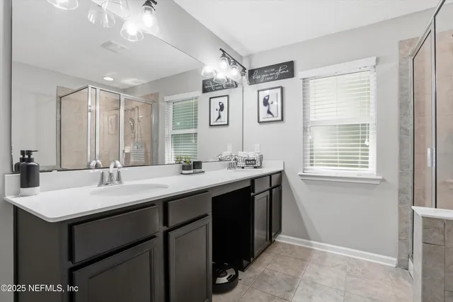 a bathroom with a sink double vanity granite tub and a mirror