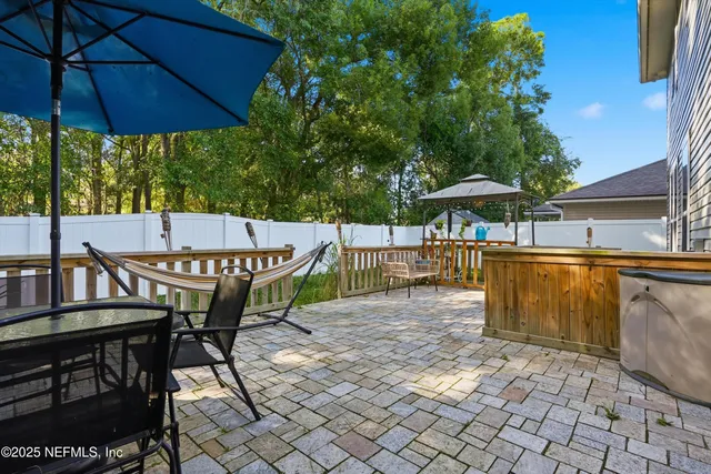 a view of a patio with table and chairs under an umbrella