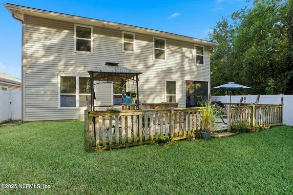 a front view of house with yard and green fence