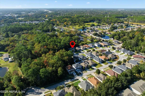 an aerial view of residential house with outdoor space and trees
