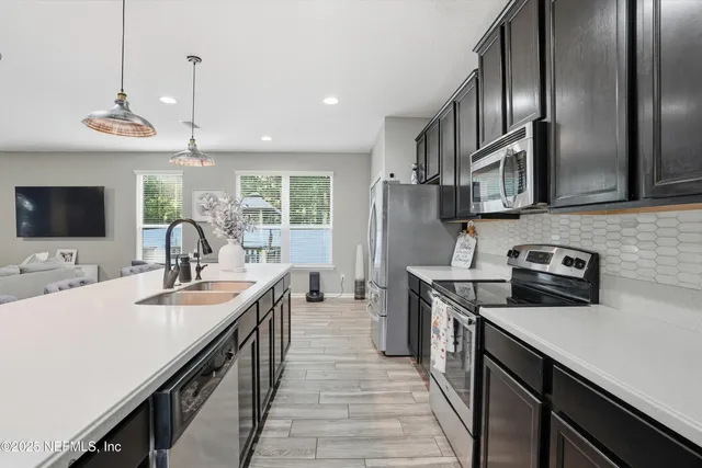 a kitchen with stainless steel appliances a sink stove and cabinets