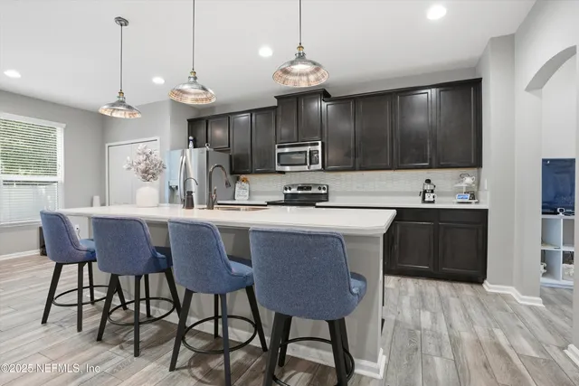 a kitchen with a table chairs sink and cabinets