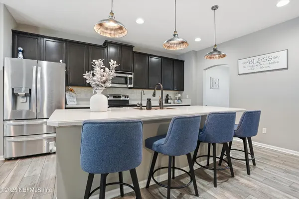 a kitchen with a table chairs refrigerator and microwave