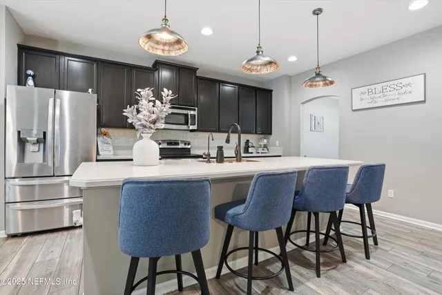 a kitchen with a table chairs refrigerator and microwave