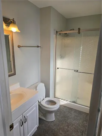 a bathroom with a granite countertop sink toilet and shower