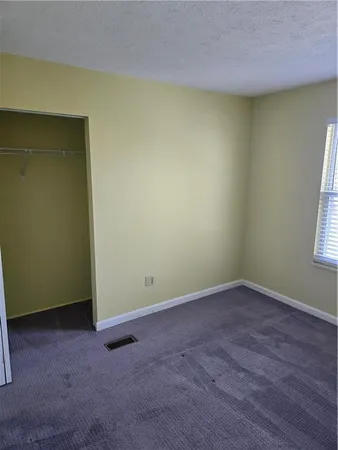 an empty room with a window and wooden floor