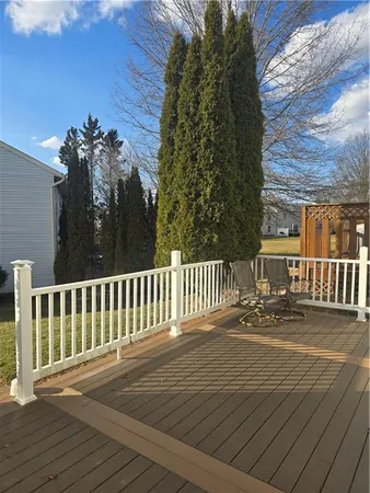 a balcony with wooden floor table and chairs